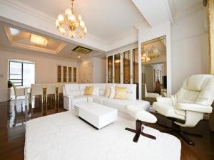a living room with white furniture and a chandelier at Hostel PLEASURE MARUYAMA in Sapporo +143 photos