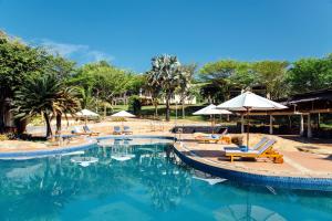 a swimming pool with chairs and umbrellas at a resort at Lazi Beach Resort in Lagi