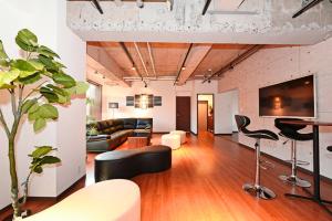 an open living room with a couch and chairs at Hostel PLEASURE MARUYAMA in Sapporo