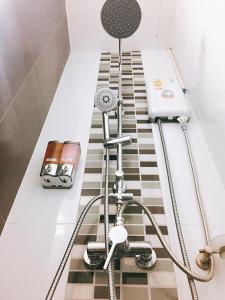 a bathroom with a shower with a hose at Sleepy and Homey Don Mueang Airport Hostel in Bangkok