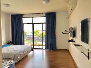 sypialnia z łóżkiem i dużym oknem w obiekcie Sleepy and Homey Don Mueang Airport Hostel w mieście Bangkok