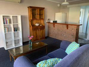 a living room with two blue couches and a coffee table at Ulladulla Harbour Motel in Ulladulla