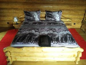 un letto con una coperta bianca e nera di Cabana Vultur a Vatra Dornei