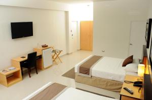 a bedroom with a bed and a desk and a television at Ixnuk Class in Piura