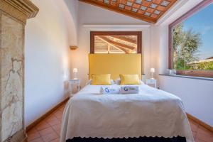 um quarto com uma cama com almofadas amarelas e uma janela em Suite Lidia B&B em Sorrento