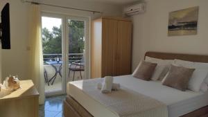 a bedroom with a bed and a balcony with a table at APARTMAN SUNCE in Baška Voda