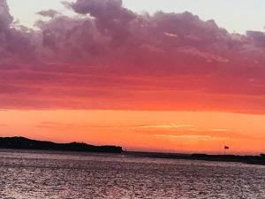 a sunset over a body of water at Salty Blue Beach House in Kalbarri +21 photos