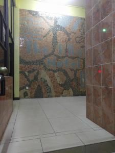 pared de mosaico en el baño con ducha en Klique Hotel Eldoret, en Eldoret