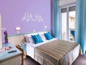 Pokój hotelowy z dużym łóżkiem z niebieskimi ścianami w obiekcie Hotel Diana w mieście Bellaria-Igea Marina +18 zdjęć