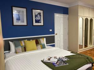 1 dormitorio con 1 cama grande y pared azul en Asoke Residence Sukhumvit by UHG en Bangkok