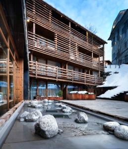 a building with a pond in front of it in the snow at M de Megève in Megève