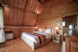 a bedroom with a bed in a wooden room at PB Pondok Gandalangu Garden House Bali in Ubud