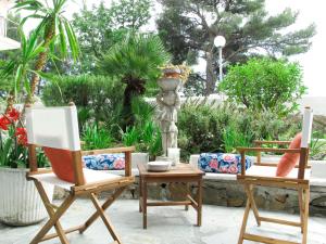 2 chaises et une table avec une statue dans le jardin dans l'établissement Apartment Arancio di Liguria - PGI211 by Interhome, à Civezza