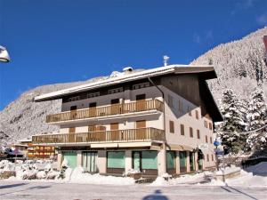 een groot gebouw met een balkon in de sneeuw bij Apartment Al Parco-1 by Interhome in Canazei