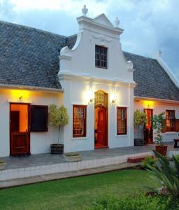 Casa blanca con puertas rojas y patio en Kronenhoff Guesthouse, en Kirkwood