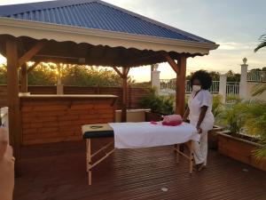 a woman in a mask standing next to a bed on a deck at THE ISLAND PARADISE in Baillif