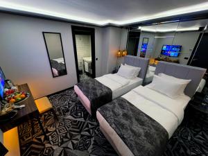 ein Hotelzimmer mit zwei Betten und einem Tisch in der Unterkunft Weingart Istanbul in Istanbul