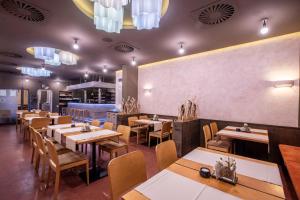 une salle à manger avec des tables et des chaises en bois dans l'établissement Hotel Olberg, à Olomučany