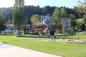 - une aire de jeux dans un parc avec un homme et un chien dans l'établissement Ferienwohnung Wehr, à Oberstaufen