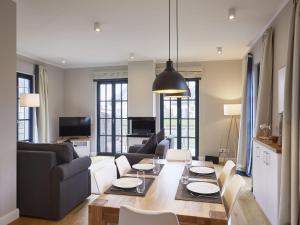 a living room with a couch and a table at Reetland am Meer - Superior Reetdachvilla mit 2 Schlafzimmern und Kamin F06 in Dranske