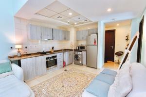 a kitchen with two couches and a kitchen with a refrigerator at Bay Central in Dubai