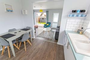 a kitchen and living room with a table and chairs at Sandbanks Braunton, Stylish Cottage near to Saunton Beach Sleeps 4 in Croyde