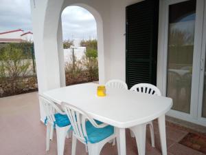 - une table et des chaises blanches sur la terrasse dans l'établissement Es Canto, à Cala Blanca