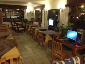 a restaurant with tables and chairs with computers on them at Hosteria Laura in San Martín de los Andes