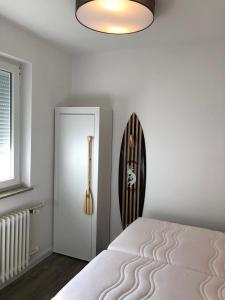 a white bedroom with a bed and a door at Seedeich in Cuxhaven