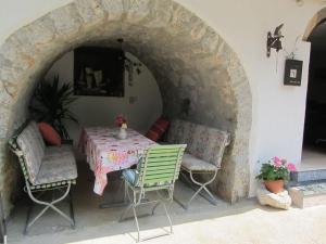 una mesa y sillas en un patio con un arco de piedra en Apartments Marijana, en Sršići