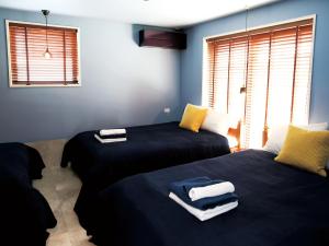 a bedroom with two beds with towels on them at CHULAX OKINAWA YOMITAN【Designer Condominium Hotel】 in Yomitan