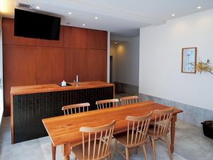 a dining room with a wooden table and chairs at CHULAX OKINAWA YOMITAN【Designer Condominium Hotel】 in Yomitan