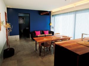 a living room with a table and a couch with pink pillows at CHULAX OKINAWA YOMITAN【Designer Condominium Hotel】 in Yomitan