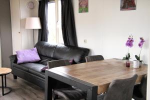un soggiorno con un tavolo e un divano di Hofgalow Chalet op camping "De Stal" a Drijber Altre 16 foto