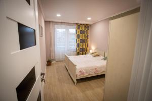 ein kleines Schlafzimmer mit einem Bett und einem Fenster in der Unterkunft Welcome Homes in Tbilisi City