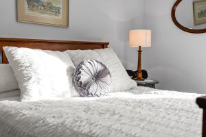 a white bed with a pillow on top of it at Coopers Cottage Battery Point in Hobart