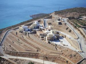 a group of white buildings on the side of a hill at Monolithos Villas in Kipri
