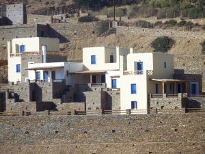 a group of white buildings sitting on top of a hill at Monolithos Villas in Kipri
