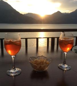 ヴァレンナにあるBellavista garden and flowersのワイン2杯、夕日を眺めながらのテーブル上のチップス1杯
