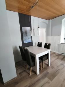 una mesa de comedor blanca con sillas negras en Ferienwohnung Familie Kowarik, en Kurort Oberwiesenthal