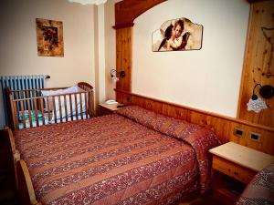 ein Schlafzimmer mit einem Bett und einem Kinderbett in der Unterkunft Hotel Moderno Restaurant in Serina