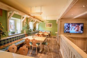 a restaurant with tables and a tv on the wall at Ferienhotel Goldhübel in Neuhausen