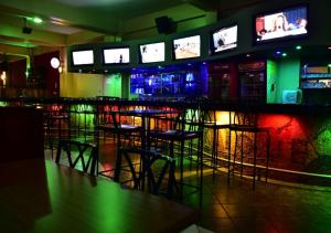 a bar with stools and televisions in a room at Klique Hotel Eldoret in Eldoret