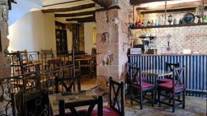 a restaurant with tables and chairs and a bar at Palacete Maria Rosa in Baños de la Encina