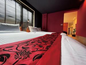 a bedroom with a large bed with a red blanket at CHULAX OKINAWA YOMITAN【Designer Condominium Hotel】 in Yomitan