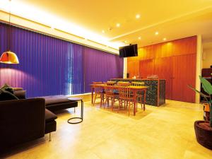 a living room with a table and a purple wall at CHULAX OKINAWA YOMITAN【Designer Condominium Hotel】 in Yomitan