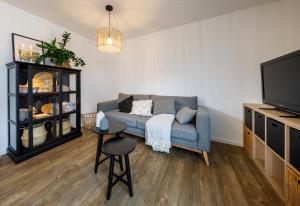 a living room with a blue couch and a tv at Tiny Cubus in Osterhofen