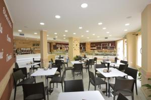 un comedor con mesas y sillas en un restaurante en B&B La Genuina en Guspini