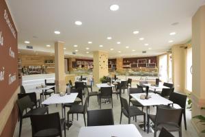 jadalnia ze stołami i krzesłami w restauracji w obiekcie B&B La Genuina w mieście Guspini