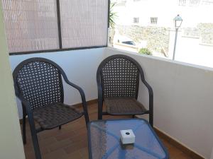 two chairs and a table in front of a window at La Luna Blanca in Torremolinos